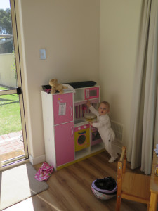 Lucy can just stretch to read the microwave in the toy kitchen