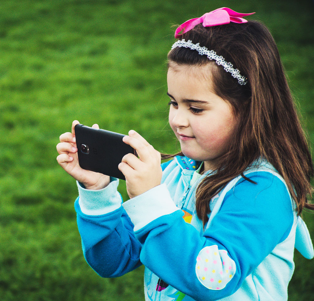 A little girl holding a phone
