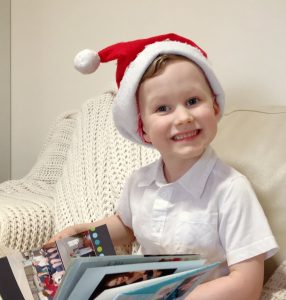 A child with Santa hat looking at a photo book